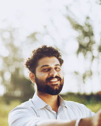 Portrait of bearded smiling young man outdoors