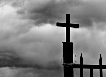 Low angle view of road sign against cloudy sky