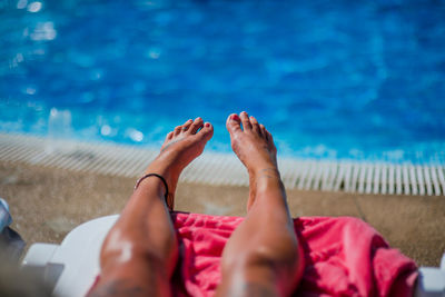 Low section of woman relaxing in swimming pool