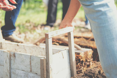 Low section of man standing on wood