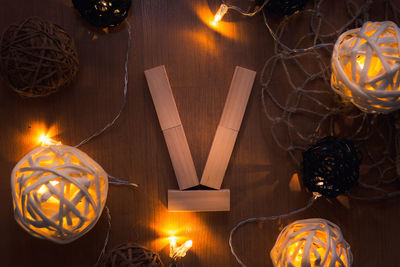 Directly above shot of letter v blocks and illuminated lights on wooden table