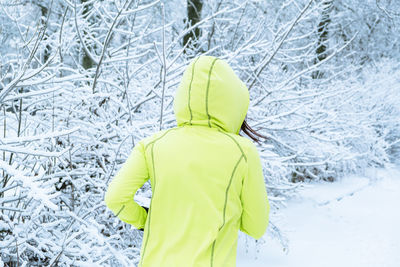 Rear view of woman standing in snow