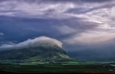 Scenic view of mountains against cloudy sky