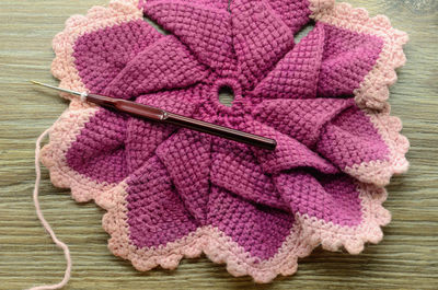 High angle view of knitted wool with needle on table