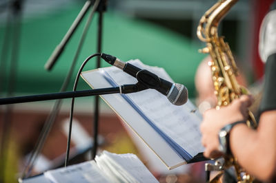 Cropped hand holding saxophone on stage