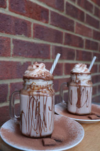 Close-up of ice cream on table against brick wall