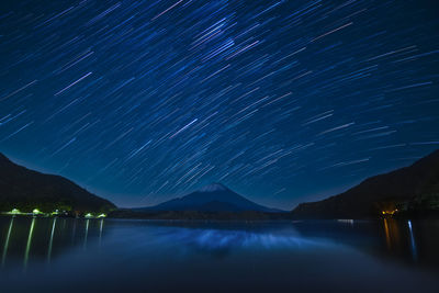 Scenic view of lake against sky at night