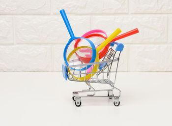 Miniature metal trolley and plastic magnifier on a white background. the concept of search and s