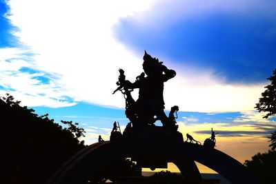 Low angle view of silhouette statue against sky during sunset