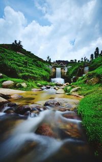 Scenic view of waterfall against sky