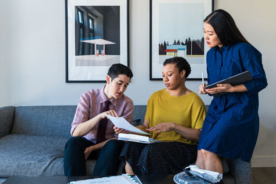 Businesswoman discussing over documents with colleagues in office