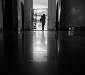 Rear view of silhouette man walking in corridor of building