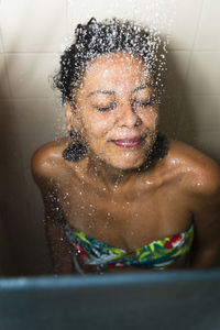 Portrait of a woman in the bathroom washing herself. 