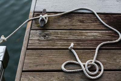 High angle view of rope tied on cleat at pier