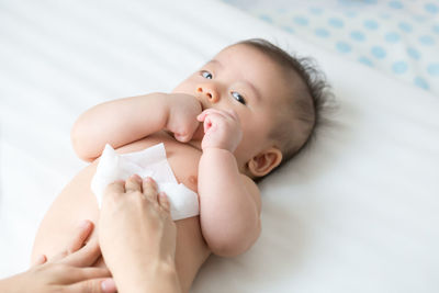 Portrait of cute baby lying on bed