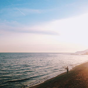 Rear view of man walking at beach