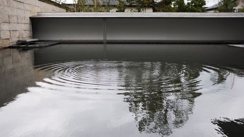 Swimming pool by lake against sky