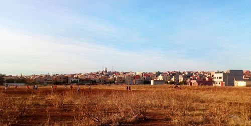 Houses on field against sky in city