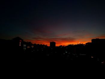 Silhouette buildings against sky during sunset