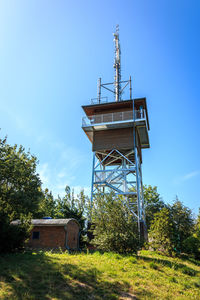 Low angle view of old tower on field against sky