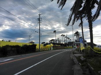 Empty road against cloudy sky