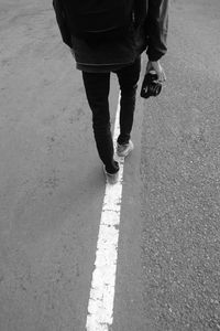 Low section of man walking on road