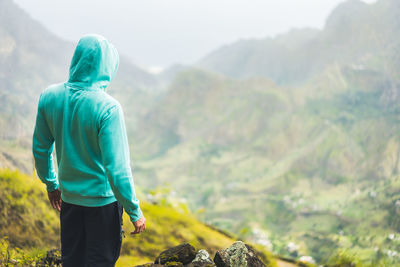 Tourist in hoodie in front of rural landscape in paul valley. santo antao island, cape verde