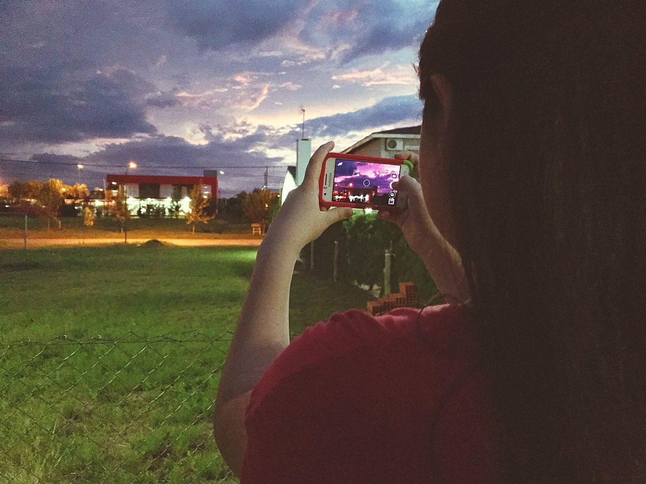 MAN PHOTOGRAPHING IN CITY AT SUNSET