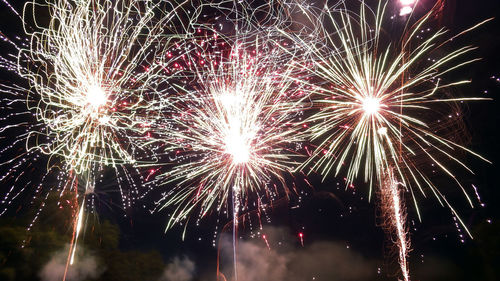 Low angle view of firework display at night