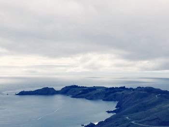 Scenic view of sea and mountains against sky