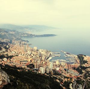 High angle view of city by sea against sky