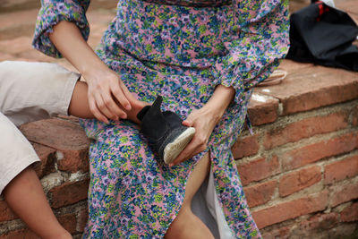 Mother fastens the shoe of his child