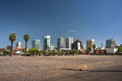 Panoramic view of city buildings against clear blue sky