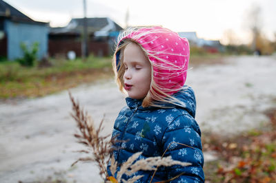 Portrait of little girl standing outdoors