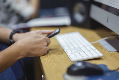 Close-up of man using laptop on table