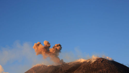 Etna volcano with smoke and ash during eruption from top crater at sunset