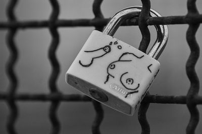 Close-up of padlocks hanging on fence