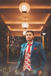 Full length of young man standing in illuminated room