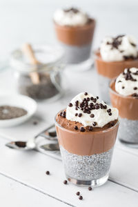 Chocolate mousse chia puddings with chia seeds in behind, ready for eating,
