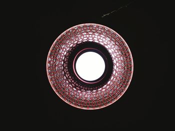 Low angle view of illuminated lamp against black background