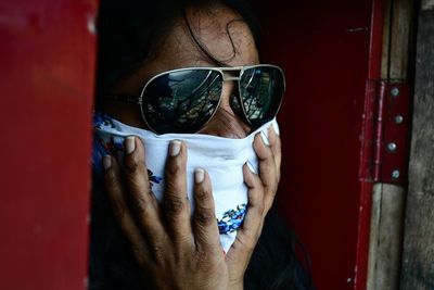 Woman in sunglasses covering face with napkin