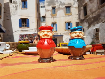 Salt and pepper shakers on tablecloth against building during sunny day