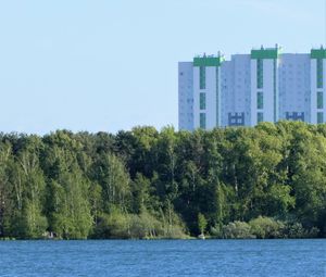Scenic view of river by buildings against clear sky