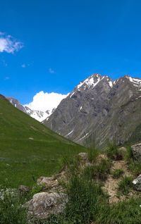 Scenic view of mountains against blue sky