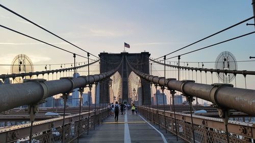 People on footbridge against sky