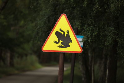 Road sign against trees