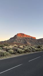 Road by mountain against clear sky