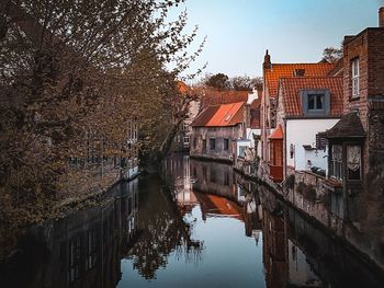 Canal amidst buildings against sky