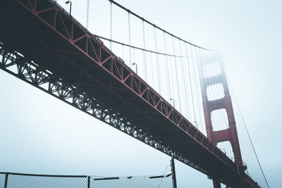 Low angle view of suspension bridge against sky