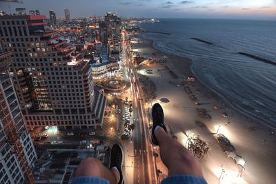 Low section of person over city against beach